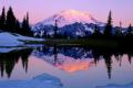Mount Rainier National Park, WA  Dawn light on Mount Rainier glaciers with reflection on icy Upper Tipsoo Lake